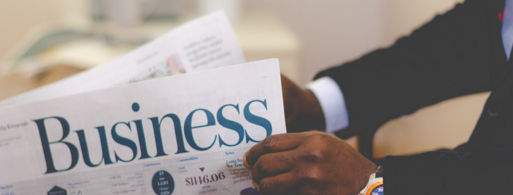 Person reading a financial newspaper, symbolizing media for financial education