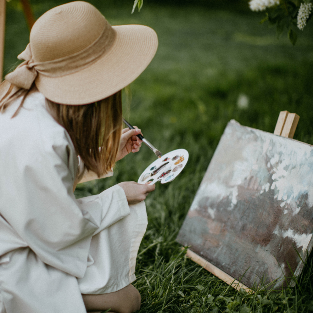 Individual engaging in outdoor painting, showcasing the therapeutic nature of artistic endeavours.