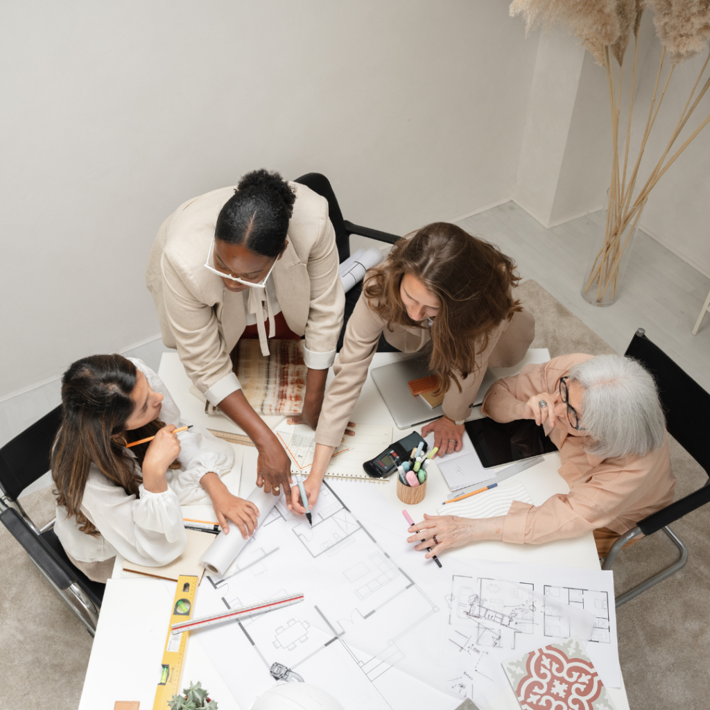 A diverse group of individuals working together on an art project, showcasing teamwork and collaboration in their artistic endeavours.