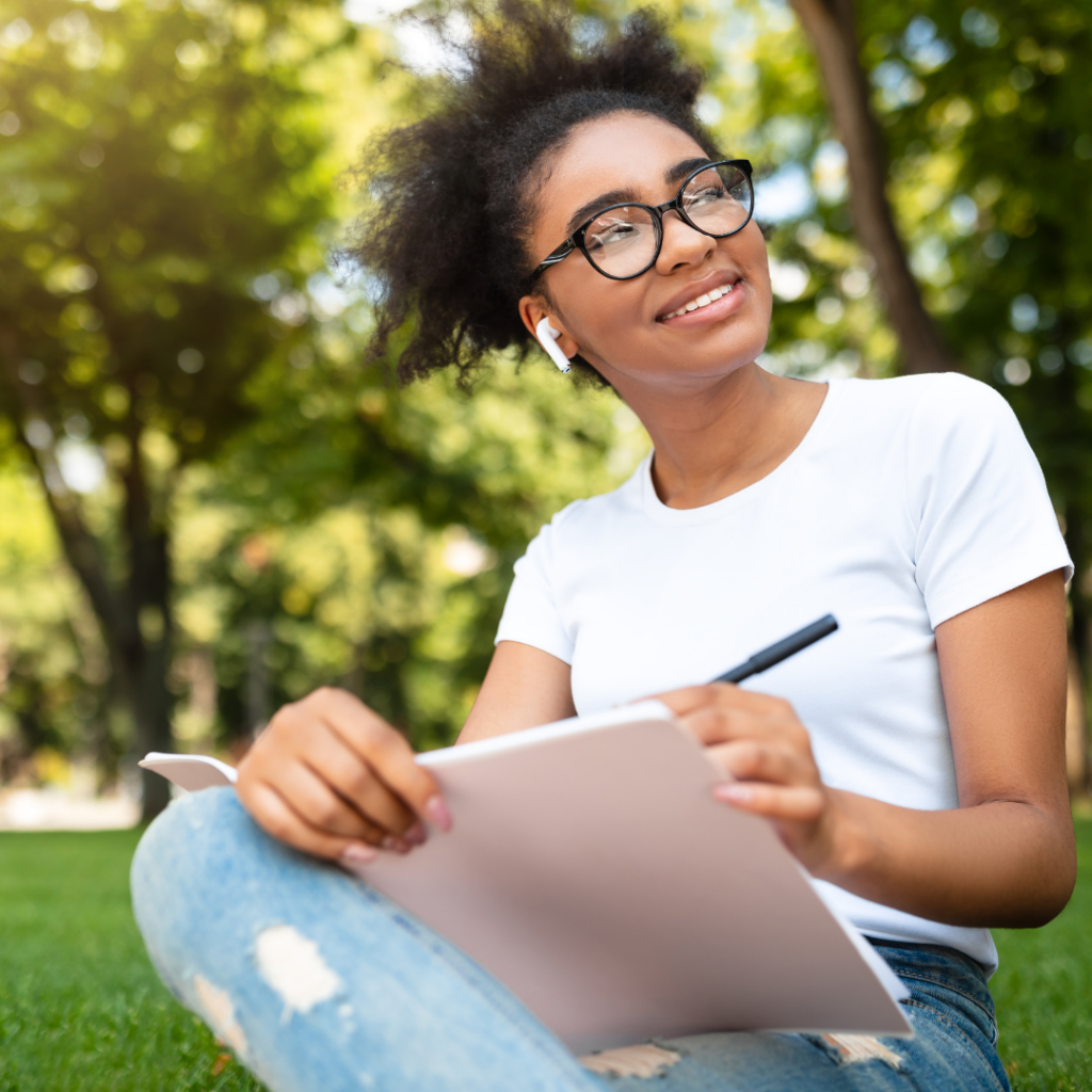 An individual sketching in a serene park setting, finding inspiration in nature for their artistic endeavours.
