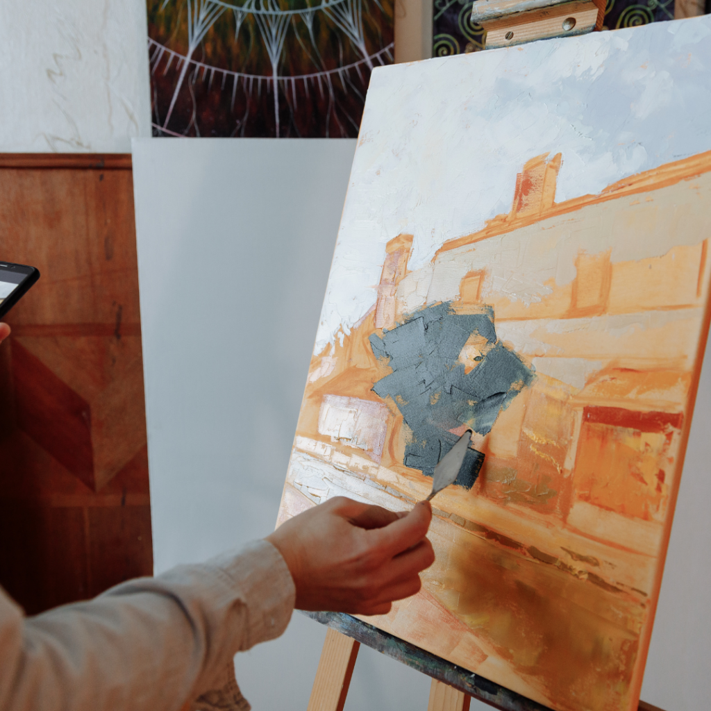 Individual engaging in therapeutic painting, focusing on calm and creativity to improve mental well-being through their artistic endeavours.