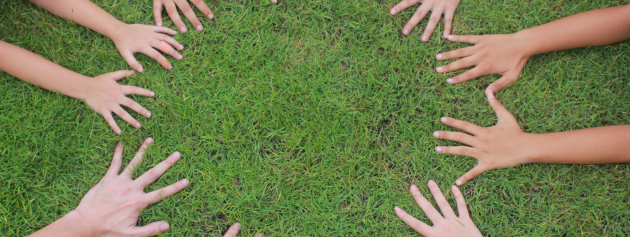 cultural narratives: hands together on grass